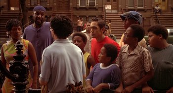 Movie still from “Crooklyn” (1994), directed by Spike Lee – A group of people standing in front of a building; Medium shot, Over the shoulder angle