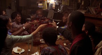 Movie still from “Crooklyn” (1994), directed by Spike Lee – A group of people sitting at a table with drinks in front of them; Medium shot, High angle