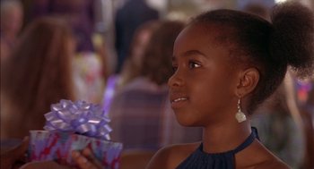 Movie still from “Crooklyn” (1994), directed by Spike Lee – A young girl holding a present in her hands; Close Up shot, Over the shoulder angle