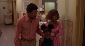 Movie still from “Crooklyn” (1994), directed by Spike Lee – A man and a woman standing next to a little girl; Medium shot, Over the shoulder angle