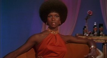 Movie still from “Crooklyn” (1994), directed by Spike Lee – A woman in a red dress with a large black afro; Medium shot, Low angle