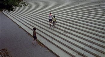 Movie still from “Crooklyn” (1994), directed by Spike Lee – Three children are walking up the stairs to go for a run; Extreme Wide shot, High angle