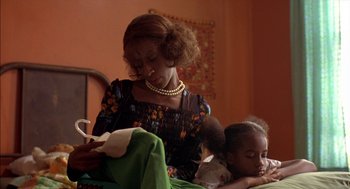 Movie still from “Crooklyn” (1994), directed by Spike Lee – A woman reading a book to a young girl; Close Up shot, Over the shoulder angle