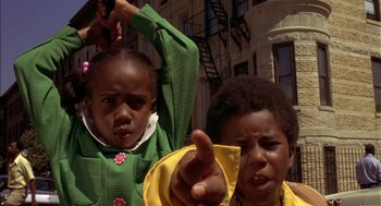 Movie still from “Crooklyn” (1994), directed by Spike Lee – Two young children standing next to each other on a city street; Close Up shot, Low angle