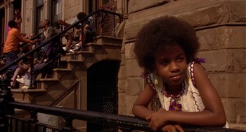 Movie still from “Crooklyn” (1994), directed by Spike Lee – A young black girl leaning on a railing in front of a building; Close Up shot, Low angle