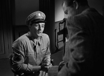 Movie still from “Crossfire” (1947), directed by Edward Dmytryk – An old photo of a man in a military uniform; Medium shot, Over the shoulder angle