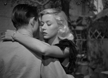 Movie still from “Crossfire” (1947), directed by Edward Dmytryk – A man and a woman embracing each other in a black and white photo; Close Up shot, High angle