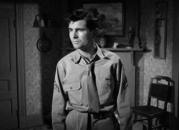 Movie still from “Crossfire” (1947), directed by Edward Dmytryk – Black and white photograph of a man in a uniform; Medium shot, Low angle