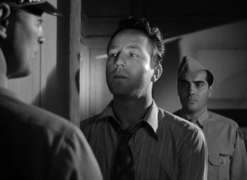 Movie still from “Crossfire” (1947), directed by Edward Dmytryk – A black and white photo of a man in a suit and tie; Close Up shot, Low angle