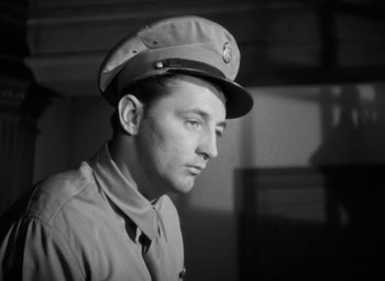 Movie still from “Crossfire” (1947), directed by Edward Dmytryk – A man in a military uniform wearing a hat; Close Up shot, Low angle
