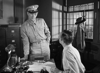 Movie still from “Crossfire” (1947), directed by Edward Dmytryk – An old photo of a man and a young boy; Medium shot, Over the shoulder angle