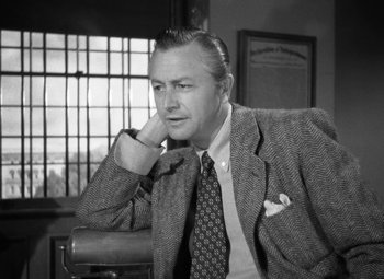 Movie still from “Crossfire” (1947), directed by Edward Dmytryk – An old photo of a man in a suit and tie; Close Up shot, Low angle