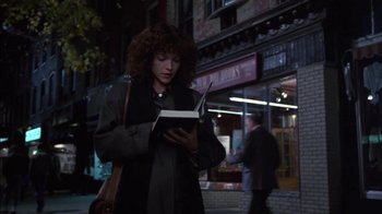 Movie still from “Crossing Delancey” (1988), directed by Joan Micklin Silver – A woman standing on the sidewalk reading a book; Medium shot, Low angle