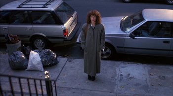 Movie still from “Crossing Delancey” (1988), directed by Joan Micklin Silver – A woman standing on the side of the street; Wide shot, High angle