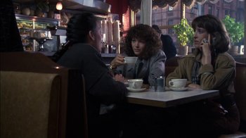 Movie still from “Crossing Delancey” (1988), directed by Joan Micklin Silver – Two women sitting at a table in front of each other; Medium shot, Over the shoulder angle