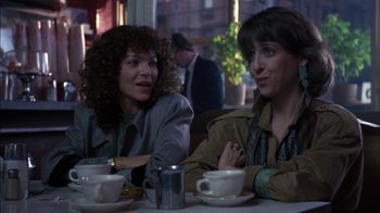 Movie still from “Crossing Delancey” (1988), directed by Joan Micklin Silver – Two women are sitting at a table with coffee cups; Medium shot, Over the shoulder angle