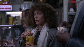 Movie still from “Crossing Delancey” (1988), directed by Joan Micklin Silver – A group of people standing next to each other eating food; Close Up shot, Over the shoulder angle