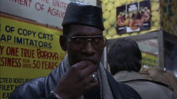 Movie still from “Crossing Delancey” (1988), directed by Joan Micklin Silver – A man wearing a hat and glasses eating a sandwich; Close Up shot, Low angle