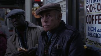 Movie still from “Crossing Delancey” (1988), directed by Joan Micklin Silver – An older man wearing a brown hat and a leather jacket; Medium shot, Low angle