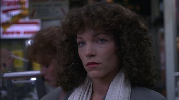 Movie still from “Crossing Delancey” (1988), directed by Joan Micklin Silver – A person with curly hair wearing a scarf; Close Up shot, Over the shoulder angle
