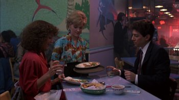 Movie still from “Crossing Delancey” (1988), directed by Joan Micklin Silver – A group of people sitting at a table with plates of food on it; Medium shot, High angle