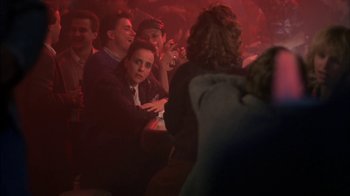 Movie still from “Crossing Delancey” (1988), directed by Joan Micklin Silver – A group of people sitting in a red room; Medium shot, Over the shoulder angle