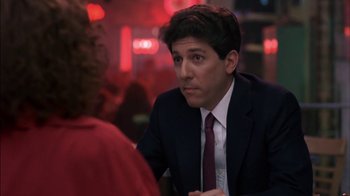 Movie still from “Crossing Delancey” (1988), directed by Joan Micklin Silver – A man wearing a suit and tie sitting at a table; Close Up shot, Over the shoulder angle