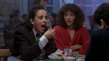 Movie still from “Crossing Delancey” (1988), directed by Joan Micklin Silver – Two women sitting at a table eating food; Medium shot, Over the shoulder angle