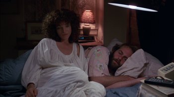 Movie still from “Crossing Delancey” (1988), directed by Joan Micklin Silver – A man and a woman sleeping in a bed; Medium shot, High angle