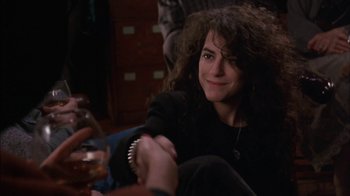 Movie still from “Crossing Delancey” (1988), directed by Joan Micklin Silver – A woman sitting on the floor with a bottle of wine; Close Up shot, Over the shoulder angle