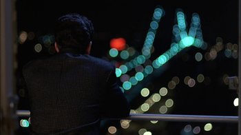 Movie still from “Crossing Delancey” (1988), directed by Joan Micklin Silver – A man standing in front of a street light at night; Medium shot, High angle
