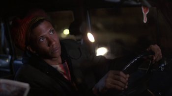 Movie still from “Crossing Delancey” (1988), directed by Joan Micklin Silver – A man sitting in the drivers seat of a car at night; Close Up shot, Low angle