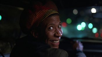 Movie still from “Crossing Delancey” (1988), directed by Joan Micklin Silver – A man with a hat on smiling for the camera; Close Up shot, Low angle