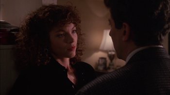 Movie still from “Crossing Delancey” (1988), directed by Joan Micklin Silver – A man and a woman standing next to each other in front of a lamp; Close Up shot, Over the shoulder angle