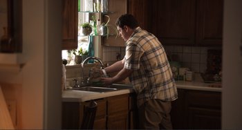 Movie still from “Cyrus” (2010), directed by Jay Duplass – A man is washing his hands in the kitchen sink; Medium shot, High angle
