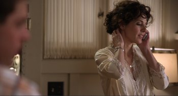 Movie still from “Cyrus” (2010), directed by Jay Duplass – A woman in a white shirt is putting on her earrings; Medium shot, Over the shoulder angle