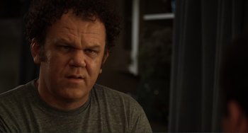 Movie still from “Cyrus” (2010), directed by Jay Duplass – An angry looking man in a gray shirt; Close Up shot, Low angle