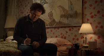 Movie still from “Cyrus” (2010), directed by Jay Duplass – A man sitting on a bed writing on a piece of paper; Medium shot, Over the shoulder angle