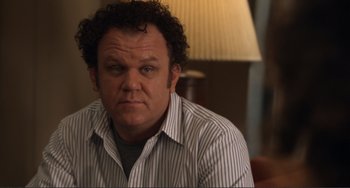 Movie still from “Cyrus” (2010), directed by Jay Duplass – A person sitting in a room with a lamp; Close Up shot, Over the shoulder angle