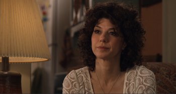 Movie still from “Cyrus” (2010), directed by Jay Duplass – A person with curly hair wearing a necklace; Close Up shot, Over the shoulder angle