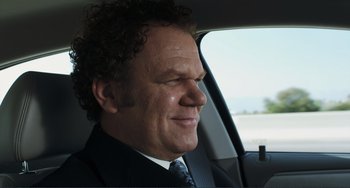 Movie still from “Cyrus” (2010), directed by Jay Duplass – A person wearing a suit and tie in a car; Close Up shot, Over the shoulder angle