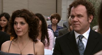 Movie still from “Cyrus” (2010), directed by Jay Duplass – A man and a woman are standing in front of other people; Close Up shot, Over the shoulder angle