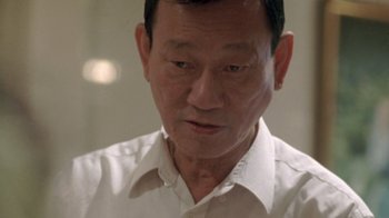 An older asian man wearing a white shirt