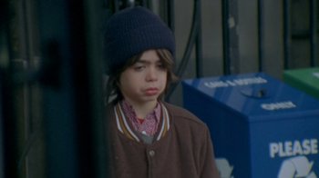 Movie still from “Daddy Longlegs” (2009), directed by Benny Safdie – A young boy wearing a blue hat and a brown jacket; Close Up shot, High angle