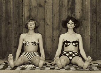 Movie still from “Daisies” (1966), directed by Vera Chytilová – A couple of women sitting on top of a blanket; Medium shot, Low angle