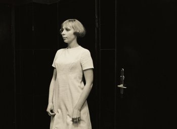 Movie still from “Daisies” (1966), directed by Vera Chytilová – A woman standing in front of a black wall; Medium shot, Low angle