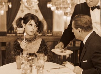 Movie still from “Daisies” (1966), directed by Vera Chytilová – A woman sitting at a dinner table with a man; Medium shot, Over the shoulder angle