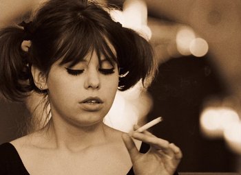 Movie still from “Daisies” (1966), directed by Vera Chytilová – A young woman smoking a cigarette in a black and white photo; Close Up shot, Low angle