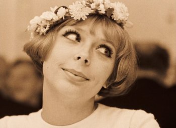 Movie still from “Daisies” (1966), directed by Vera Chytilová – A person wearing a flower crown; Close Up shot, Low angle
