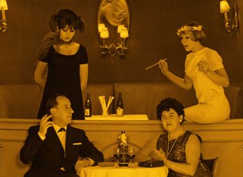 Movie still from “Daisies” (1966), directed by Vera Chytilová – A group of people sitting around a table; Medium shot, High angle